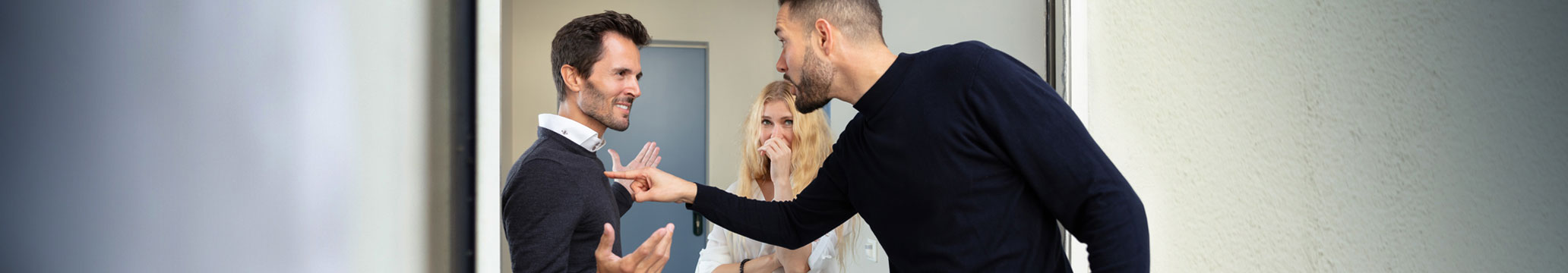 
two men arguing while a woman watches