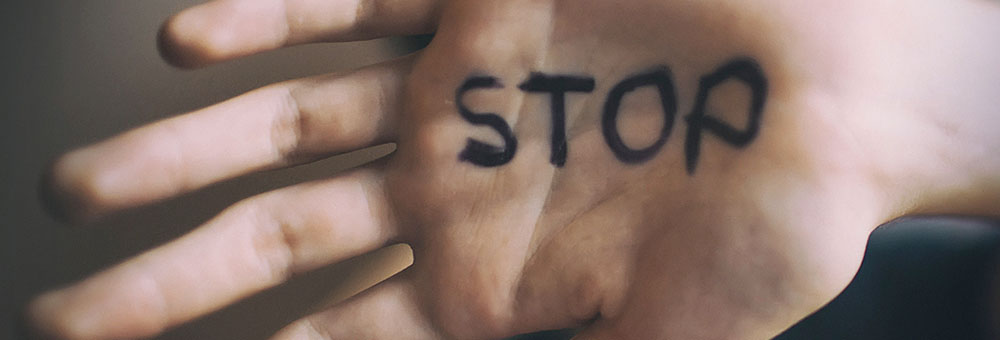 the word stop written on someone's hand