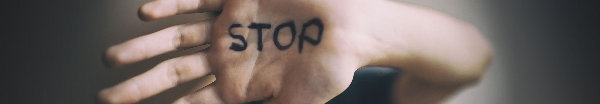the word stop written on someone's hand